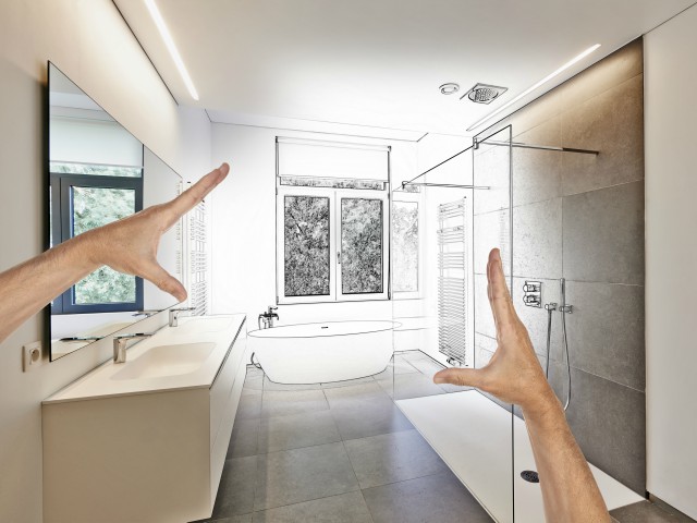 Photo of someone's hands framing up a modern bathroom design